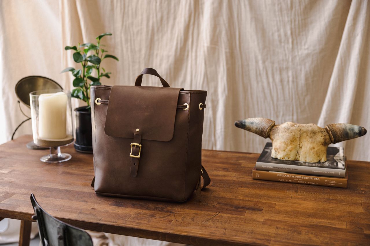 WP standard midland bag, kept on a wooden table next to plants and a candle.