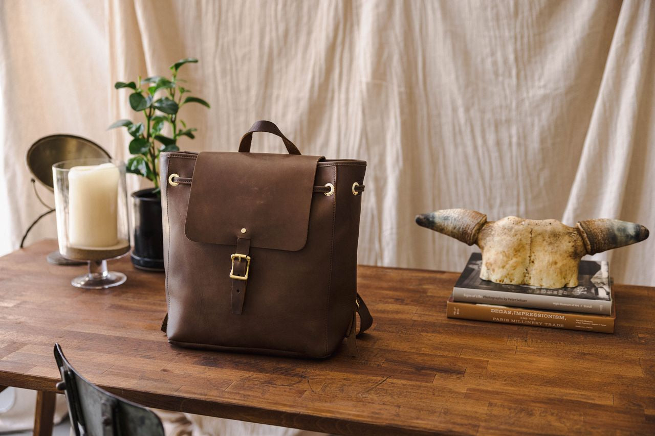 WP standard midland bag, kept on a wooden table next to plants and a candle.