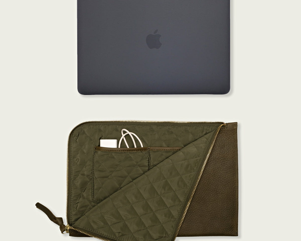 Sleek leather laptop sleeve with compartments for tech accessories, ideal for professionals and students.