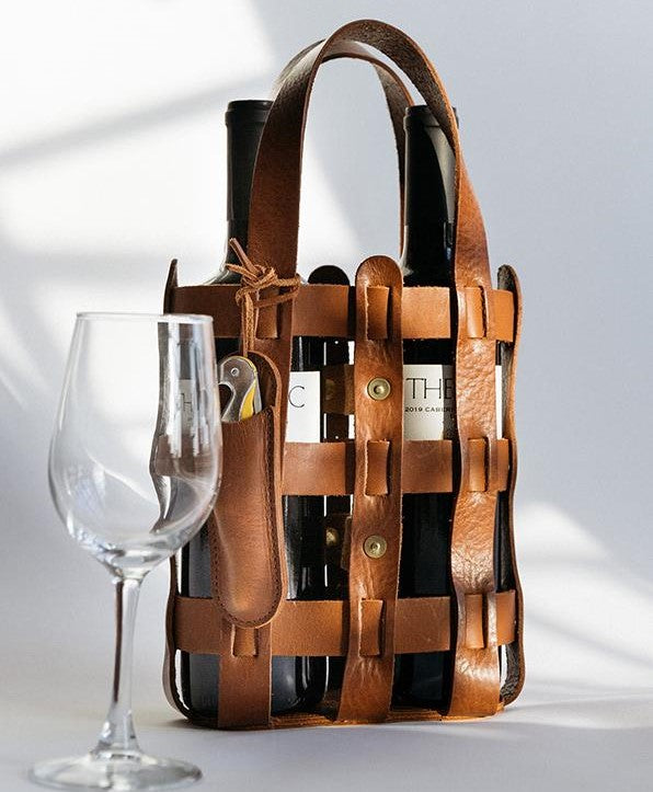 A wine tote bag from WP Standard, along with a wine glass against a white background.