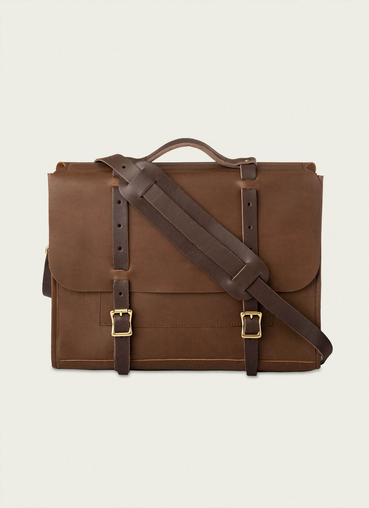 Brown leather briefcase with brass buckles and adjustable strap.