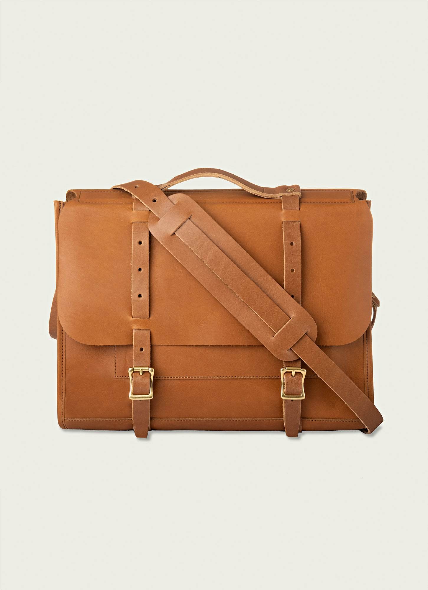 Tan leather messenger bag with buckle closure and padded shoulder strap for everyday commuting.