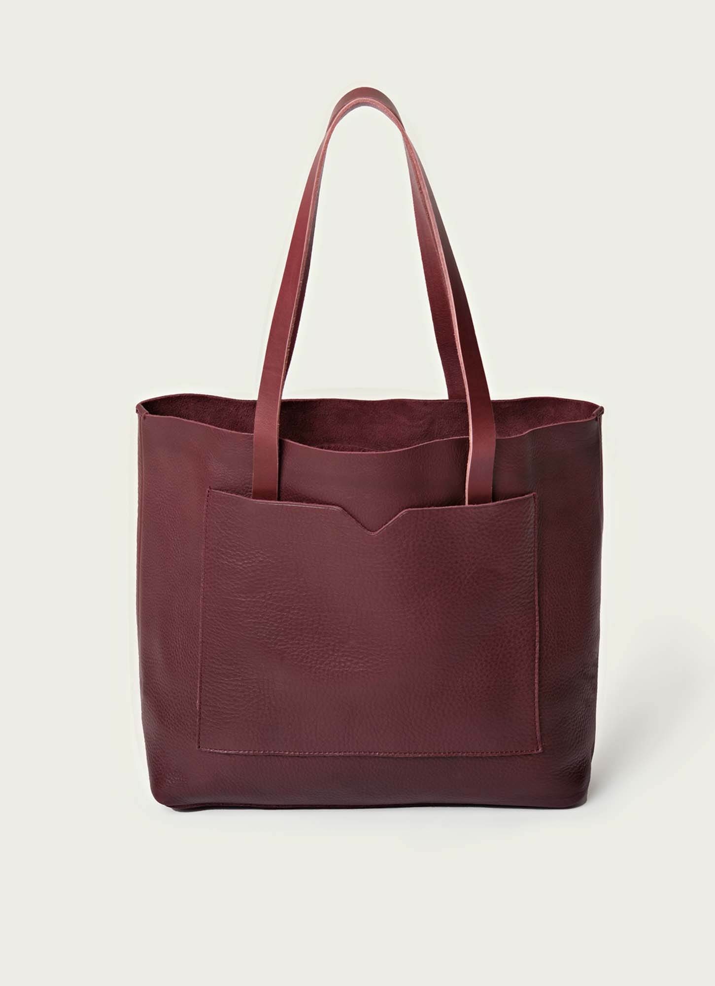 Elegant burgundy leather tote bag with a deep front pocket and sturdy handles, perfect for work, travel, or everyday use. Stylish and spacious handbag for women seeking durability and sophistication.