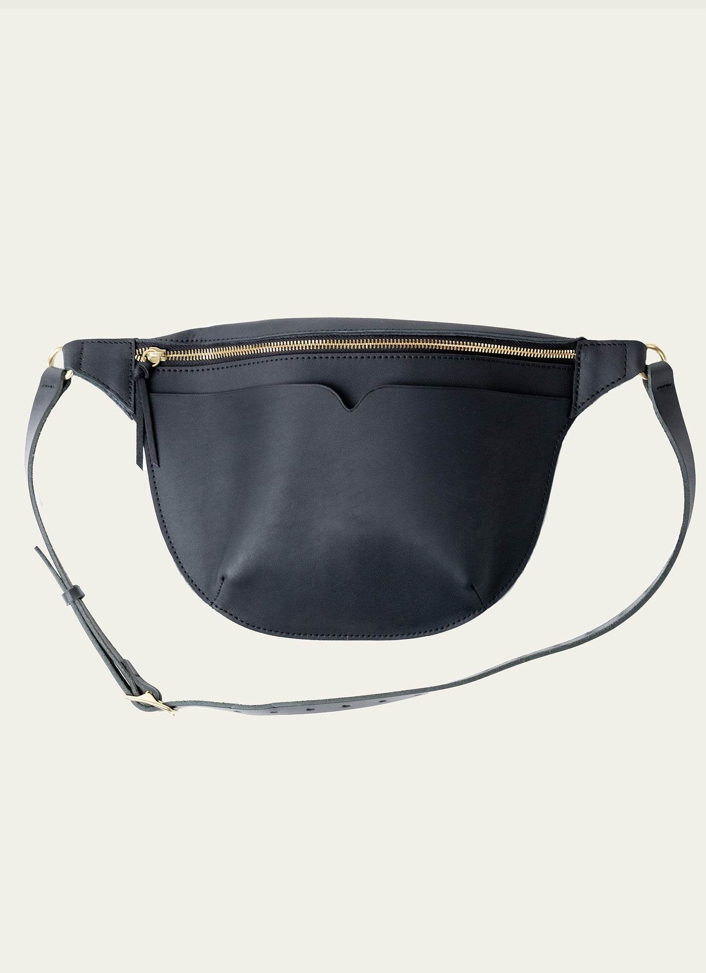 Elegant black leather crossbody fanny pack with gold zipper and adjustable strap, perfect for secure and stylish hands-free carrying.