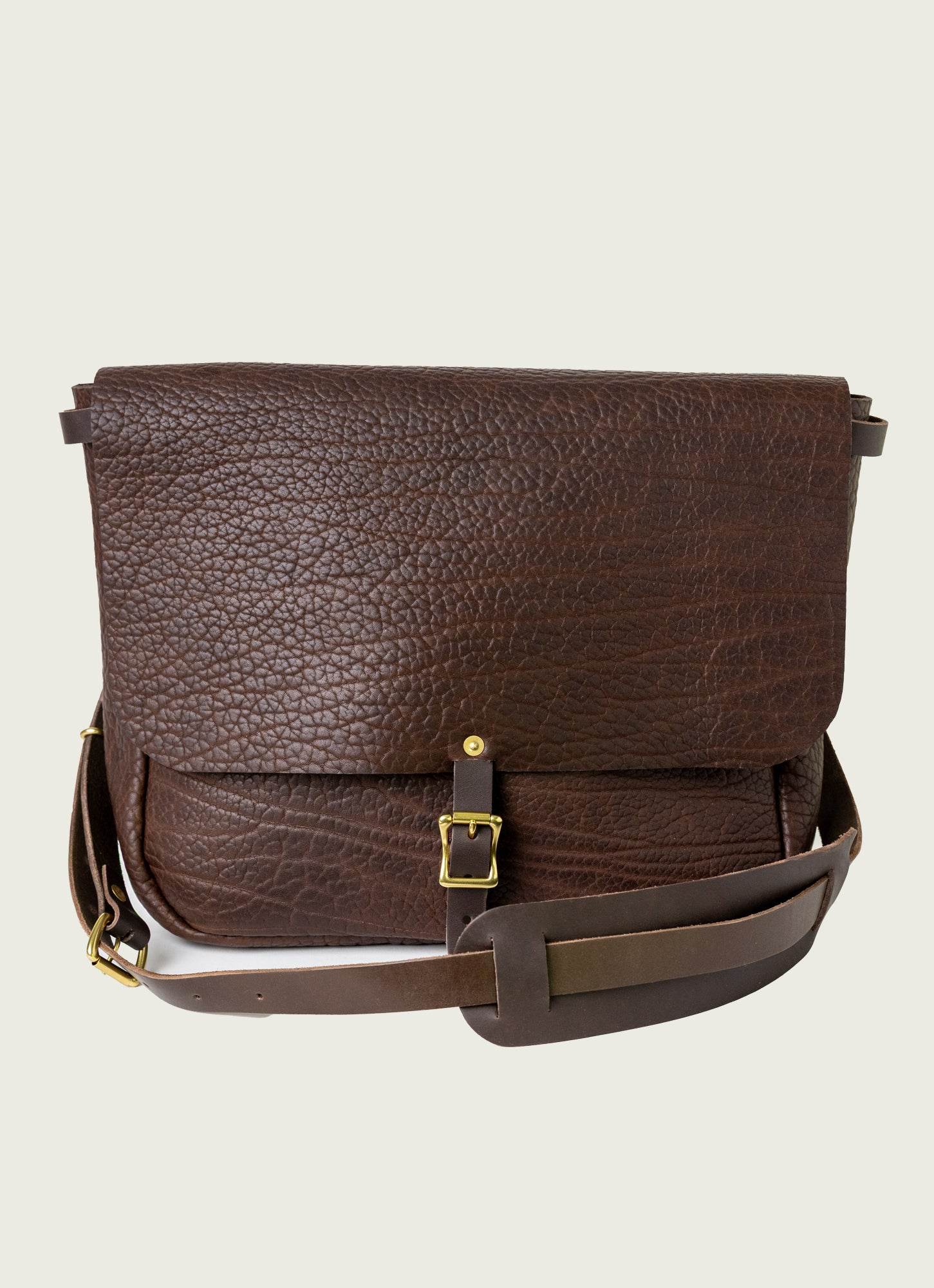Rugged leather messenger bag with laptop sleeve and magnetic flap, ideal for commuters.