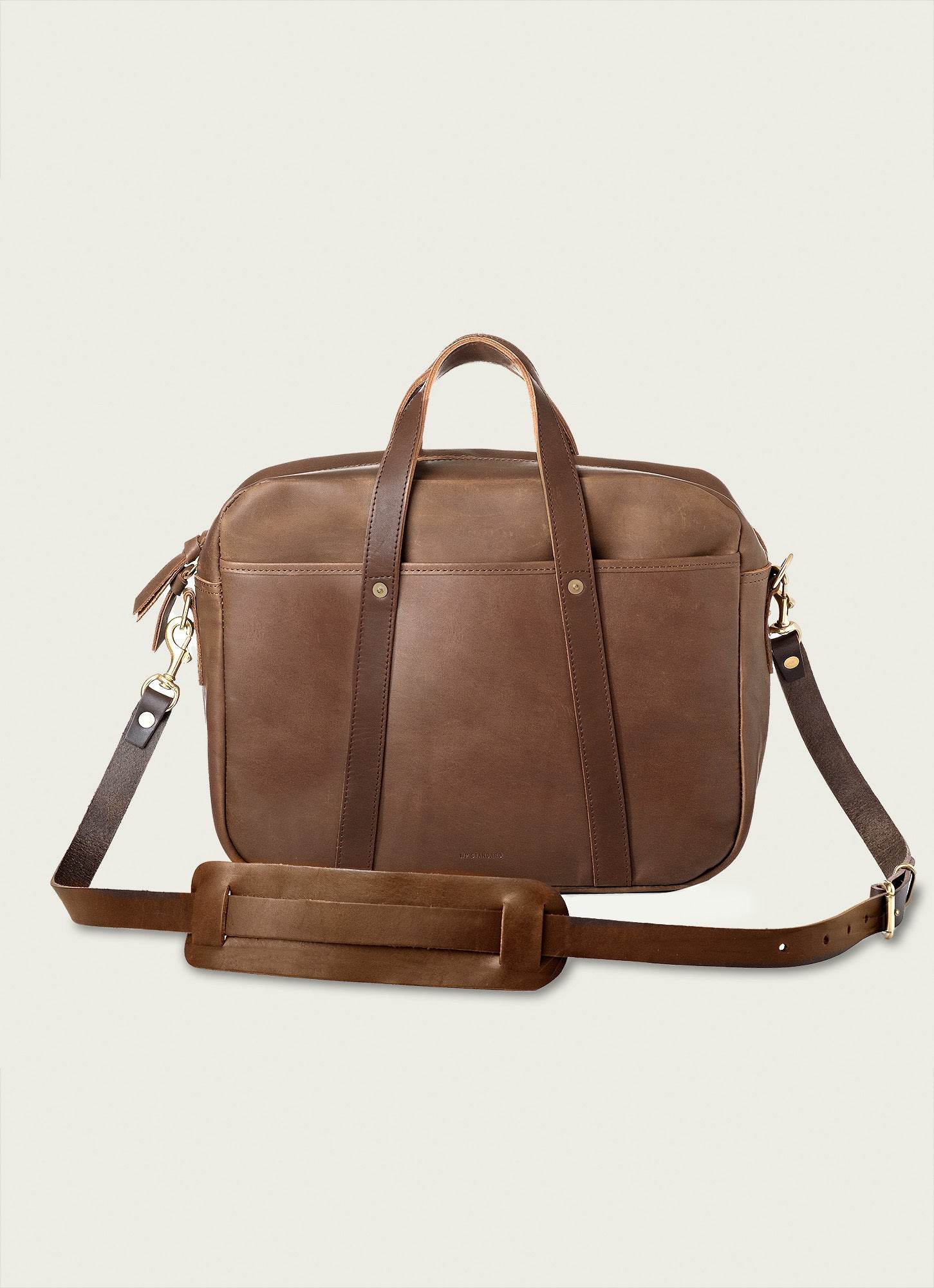 Brown leather briefcase with top handles and adjustable strap, perfect for work or business travel.