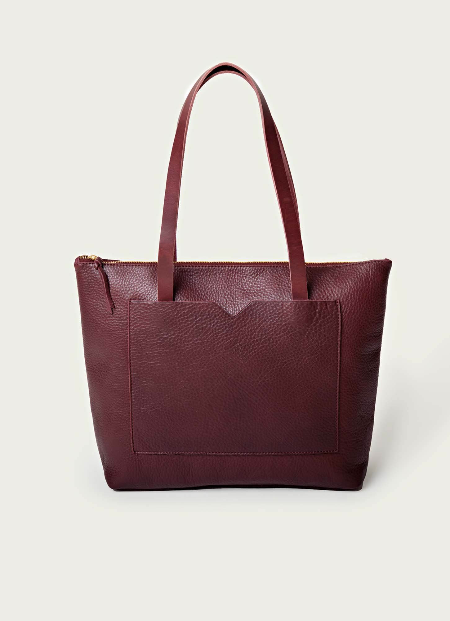 Burgundy pebbled leather tote with scalloped front pocket, gold zipper closure, and structured silhouette.