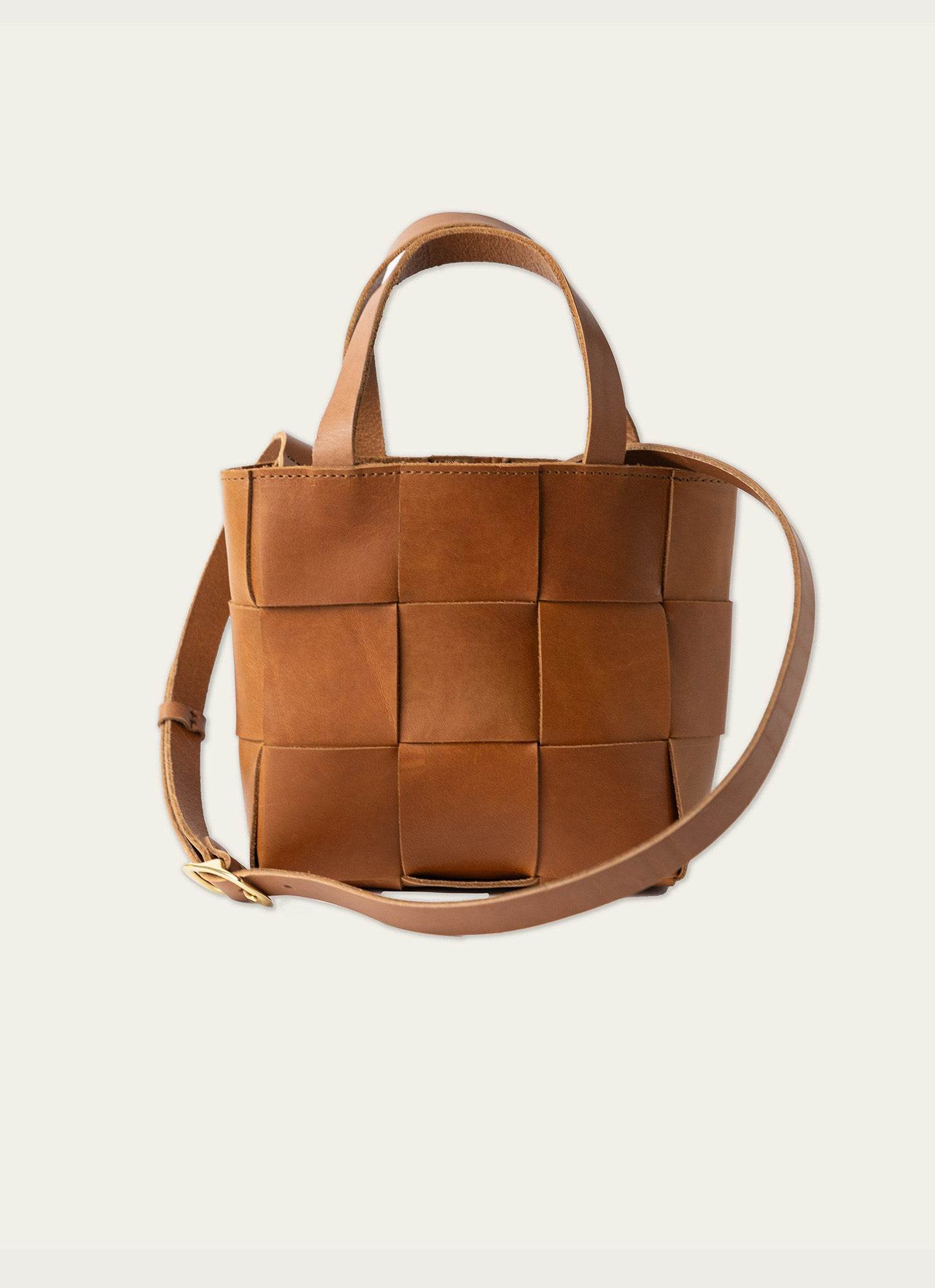 Chic brown leather crossbody bag with woven design, top handles, and adjustable strap – versatile and stylish handbag for everyday fashion.
