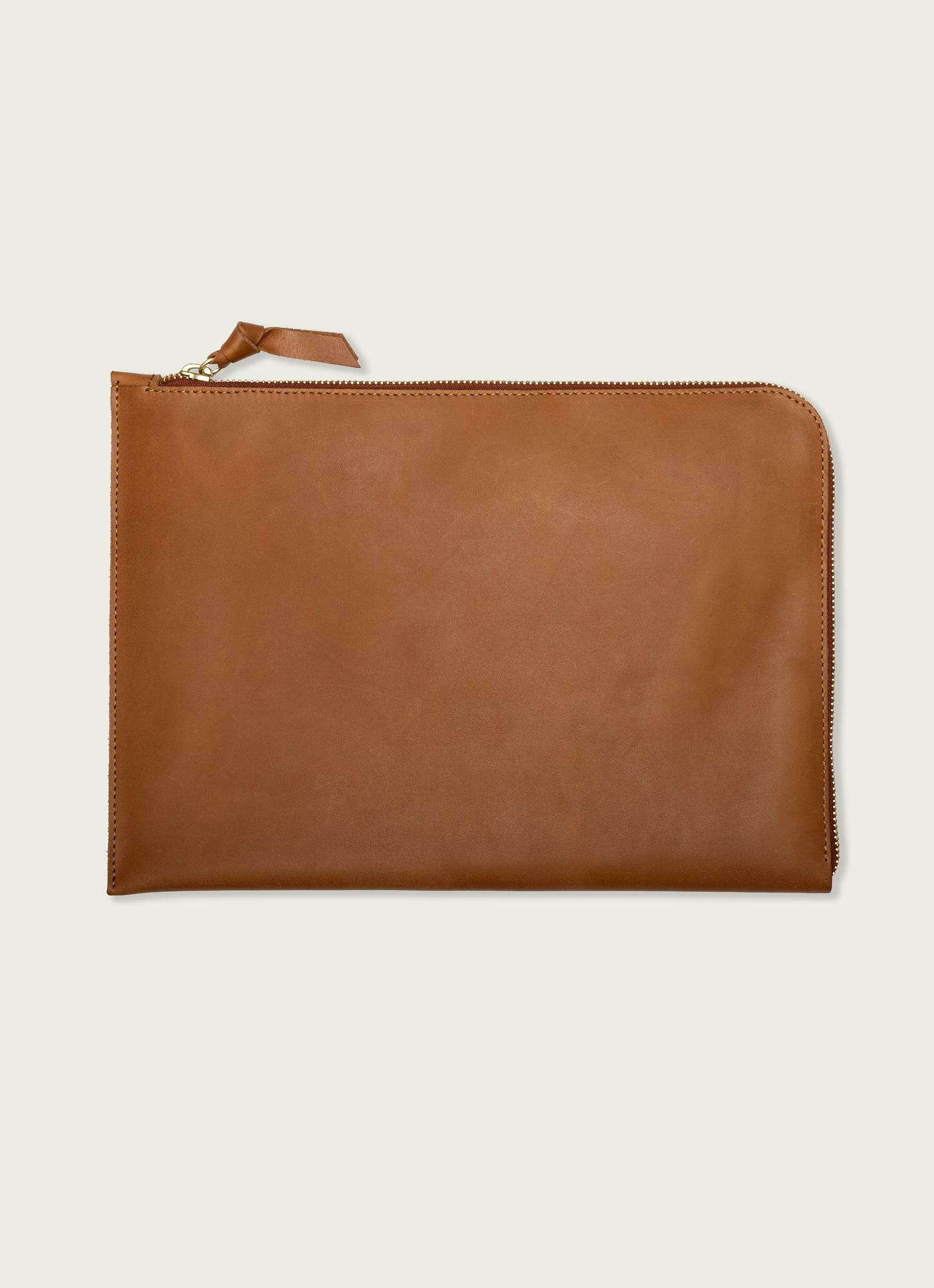 Minimalist tan leather utility pouch with top zip closure, ideal for organizing travel toiletries or tech gear.