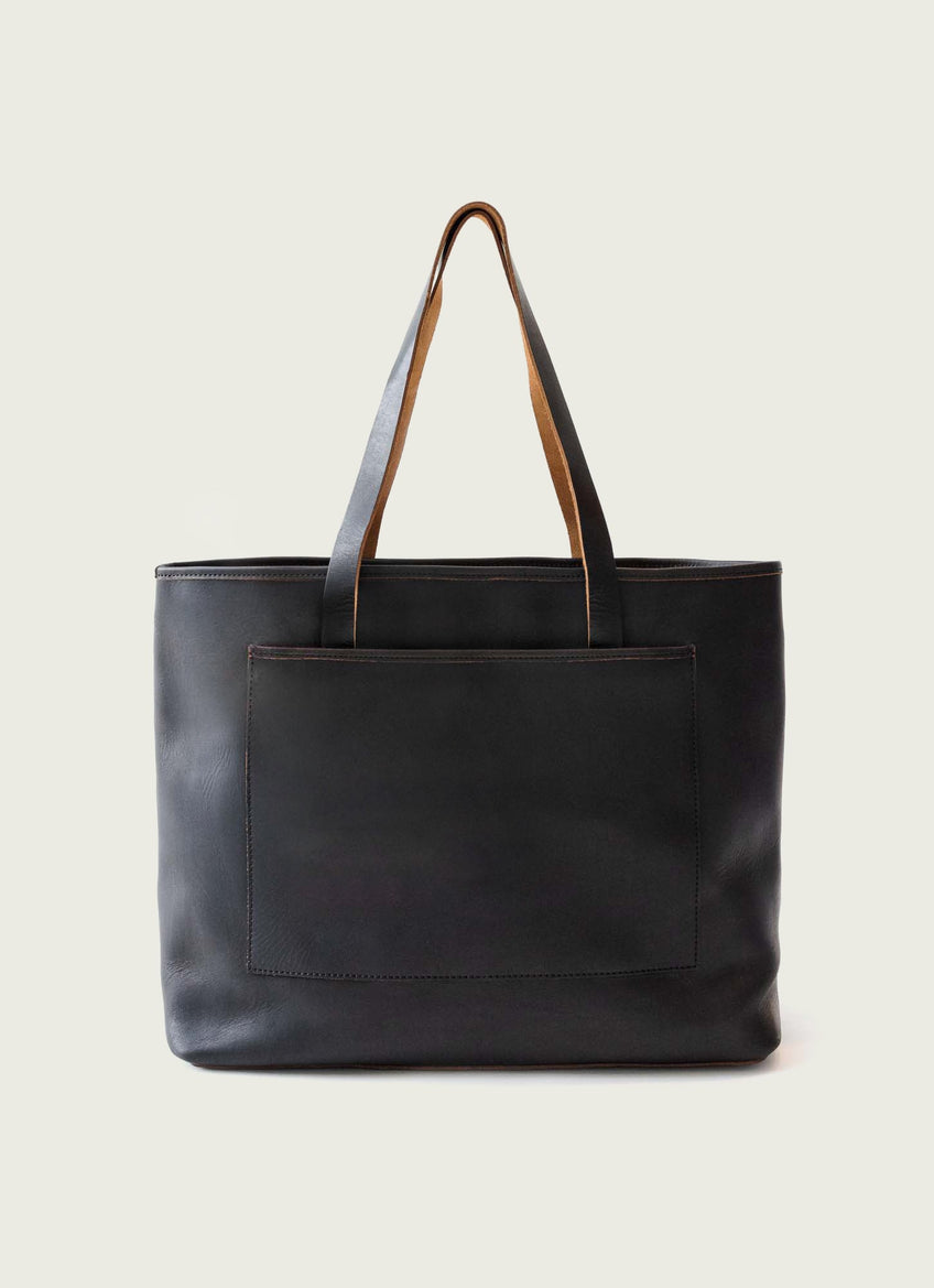 Black leather tote bag with contrasting tan straps and a front pocket, ideal for work or everyday use.